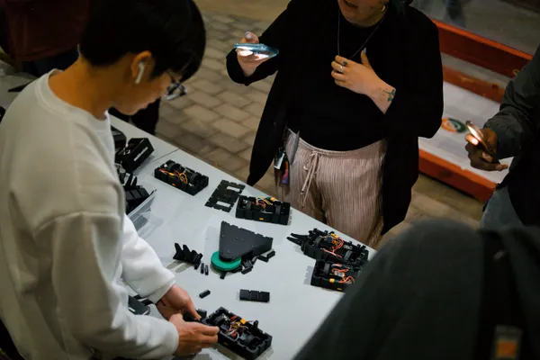 An individual is working on assembling robot components at a table.